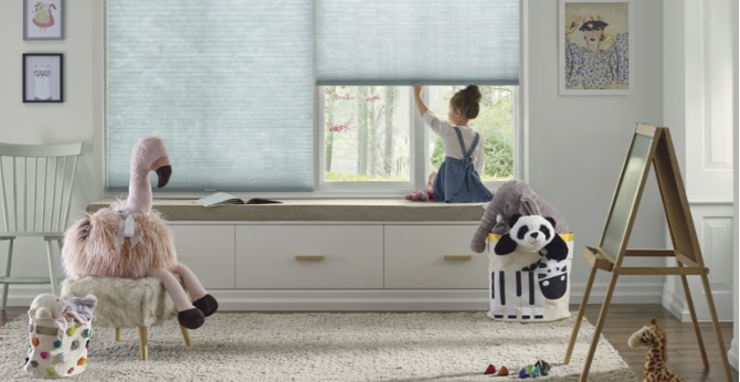 child sitting by a window with blue blinds